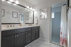 Bathroom with a stall shower, double vanity, and light marble finish flooring