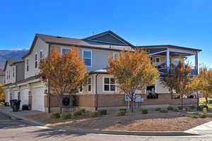 View of front of property with brick siding and a balcony