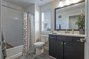 Bathroom with shower / tub combo with curtain, vanity, and dark wood-type flooring