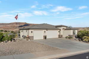 Prairie-style house with an attached garage, driveway, stucco siding, a tile roof, and a mountain view