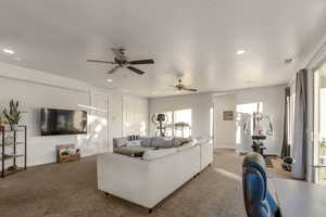 Carpeted living room featuring ceiling fan and recessed lighting