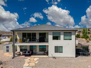 Back of property featuring a trampoline, a patio area, outdoor lounge area, stucco siding, and a balcony