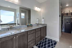 Full bath featuring recessed lighting, double vanity, a walk in closet, and concrete floors