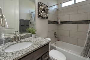 Full bath featuring shower / bath combination with curtain and vanity