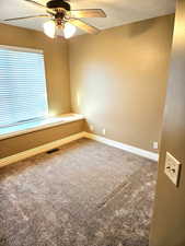 Unfurnished room featuring carpet flooring, a textured ceiling, and a ceiling fan