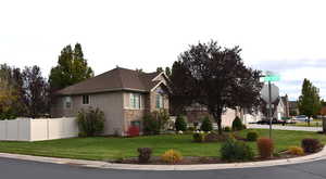 View of side of home with stone siding, stucco siding, and roof with shingles