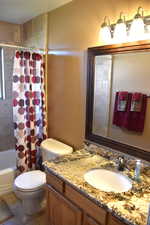 Bathroom featuring shower / tub combo, vanity, and tile patterned floors