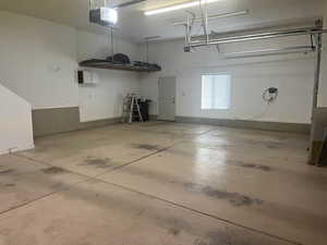 Garage with a garage door opener and baseboards