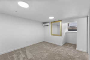Basement with baseboards and light colored carpet