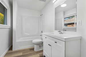 Bathroom featuring vanity, bathtub / shower combination, and light wood-style floors