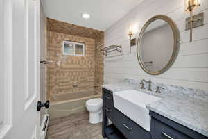 Downstairs Bathroom with bathtub / shower combination, vanity, baseboard heating, light wood finished floors, and recessed lighting