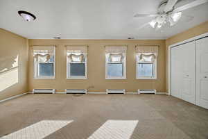 Unfurnished upstairs bedroom with carpet and baseboard heating
