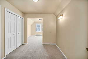 Bonus room or sitting area featuring carpet floors, vaulted ceiling, and baseboard heating