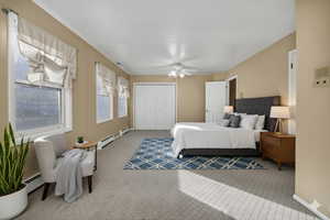 Virtually Staged Carpeted bedroom featuring a closet, ceiling fan, a baseboard heating unit, and baseboard heating