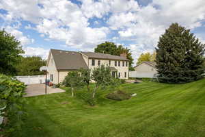 Rear view of property with a fenced backyard, a patio area, a chimney, and a shingled roof