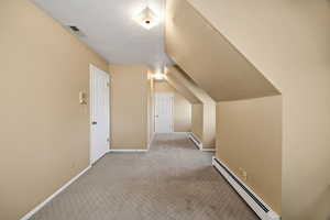 Upstairs Bedroom with a textured ceiling, baseboard heating, carpet, and lofted ceiling