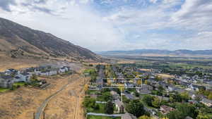 Aerial overview of property's location with nearby suburban area, a mountain backdrop, and property parcel outlined