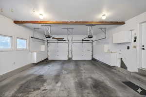 Virtually Staged or unstaged Garage featuring double garage doors and a concrete floor.