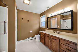 Primary Bathroom with vanity, a shower, and baseboard heating