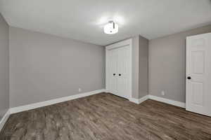 Unfurnished bedroom featuring wood finished floors and a closet