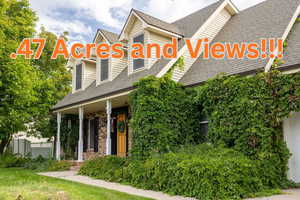 View of front facade with roof with shingles, covered porch, brick siding, a front yard, and a garage