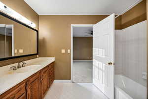 Primary Full bathroom featuring vanity, light tile patterned floors, bathtub / shower combination, and a ceiling fan