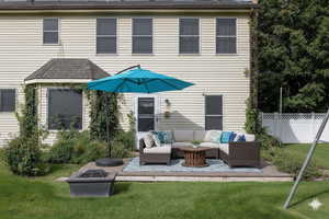 Virtually Staged Deck at Back of house featuring a shingled roof, and an outdoor living space with a fire pit