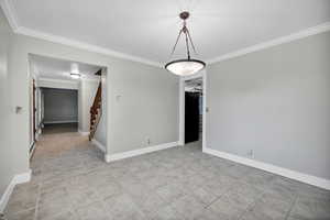 Formal dining room featuring crown molding, stairs, light tile patterned floors, and a baseboard heating unit