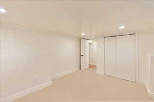 Unfurnished bedroom with recessed lighting, carpet, and a closet