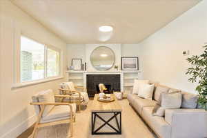 Living area featuring a brick fireplace, built in features, and wood finished floors