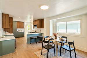 Dining room with light wood-type flooring and baseboards