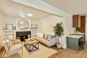 Living area featuring light wood-type flooring and a brick fireplace