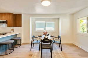 Dining space with light wood finished floors and baseboards