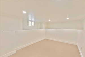 Basement with carpet floors, crown molding, and recessed lighting