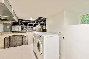 Laundry area featuring water heater and washer and clothes dryer