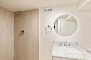 Full bath with vanity and a shower