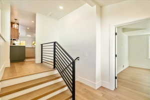 Stairway with wood finished floors and recessed lighting