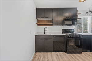 Kitchen featuring open shelves, black appliances, and light wood-type flooring