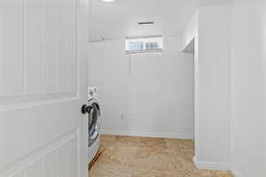 Laundry room featuring washer / dryer and baseboards