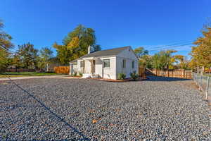 View of front of property featuring a fenced backyard, brick siding, a chimney, concrete driveway, and a garage