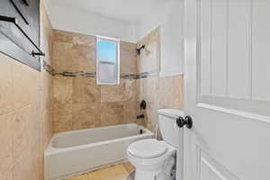 Full bath featuring tub / shower combination and tile patterned flooring