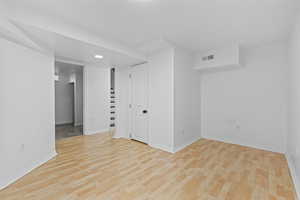 Below grade area with light wood finished floors and recessed lighting