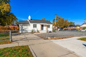 View of front facade with a gate, driveway, a fenced front yard, a garage, and a chimney