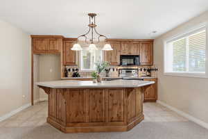 Kitchen featuring light tile patterned floors, pendant lighting, decorative backsplash, and brown cabinetry