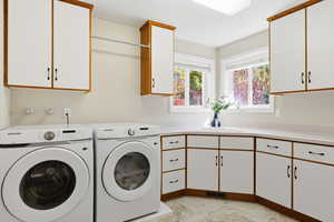 Washroom featuring washing machine and clothes dryer and cabinet space