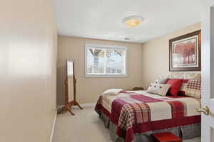 Bedroom with light carpet and baseboards