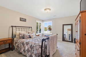 Bedroom featuring light carpet and a textured ceiling