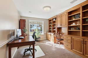 Office space featuring light carpet and a textured ceiling