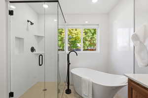 Full bathroom featuring a soaking tub, vanity, a stall shower, and recessed lighting