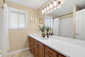 Bathroom featuring vanity, a shower with shower curtain, and light tile patterned floors